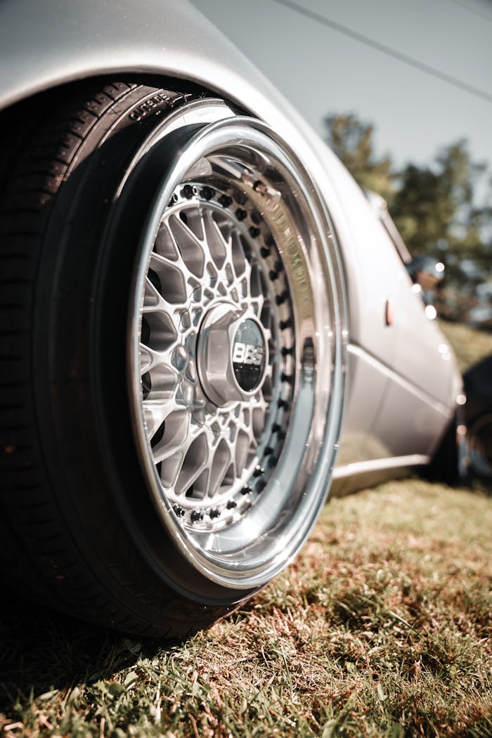 Detailed close-up of a stylish car wheel with a BBS rim on grass.